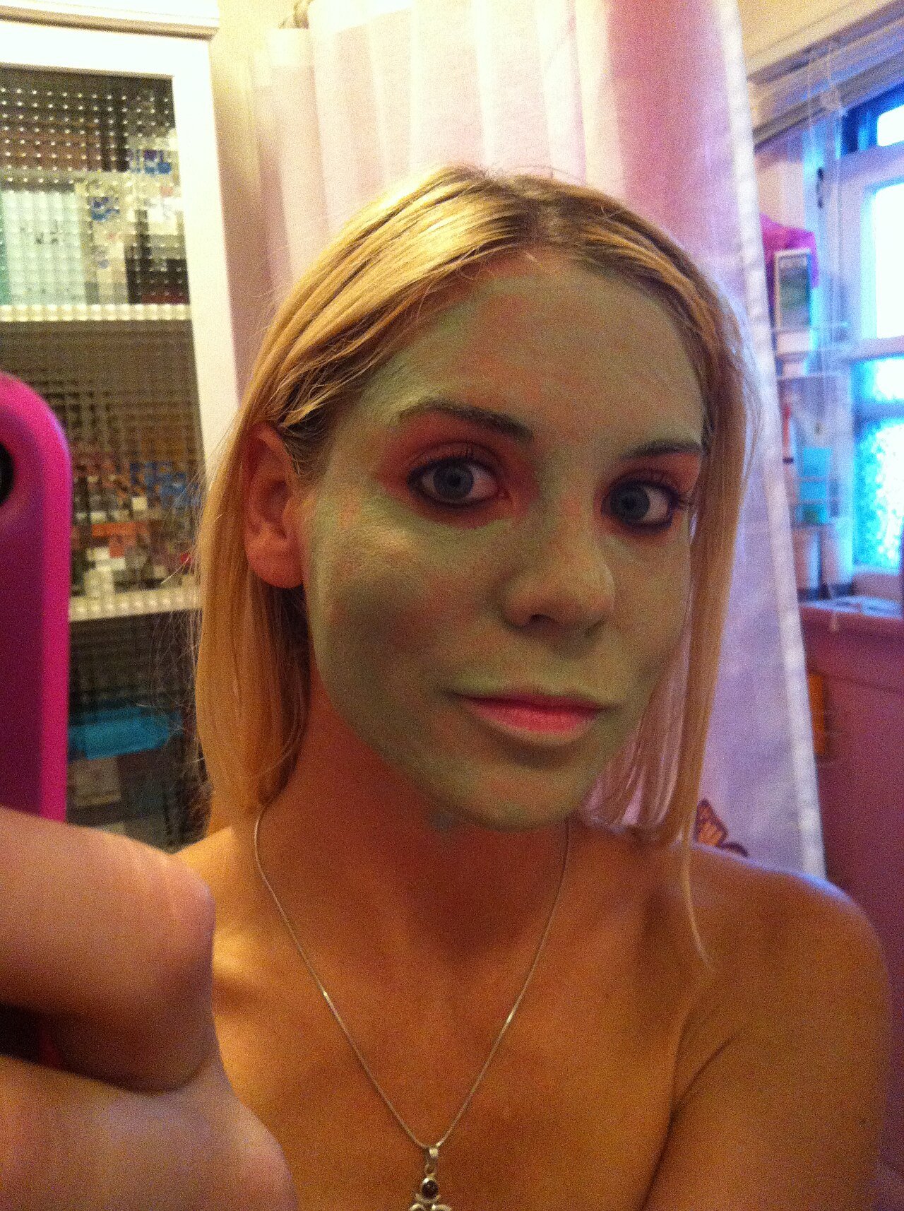 A green tea sheet mask applied to the face